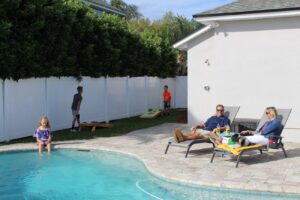 family relaxing in the backyard by the pool